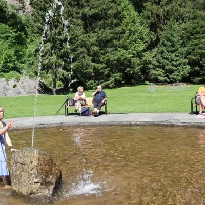 People are sitting on benches around a fountain
