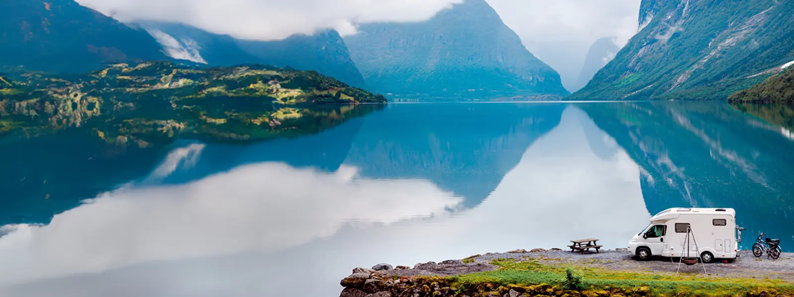 Wohnmobil geparkt am Fjord und schönen Bergen.