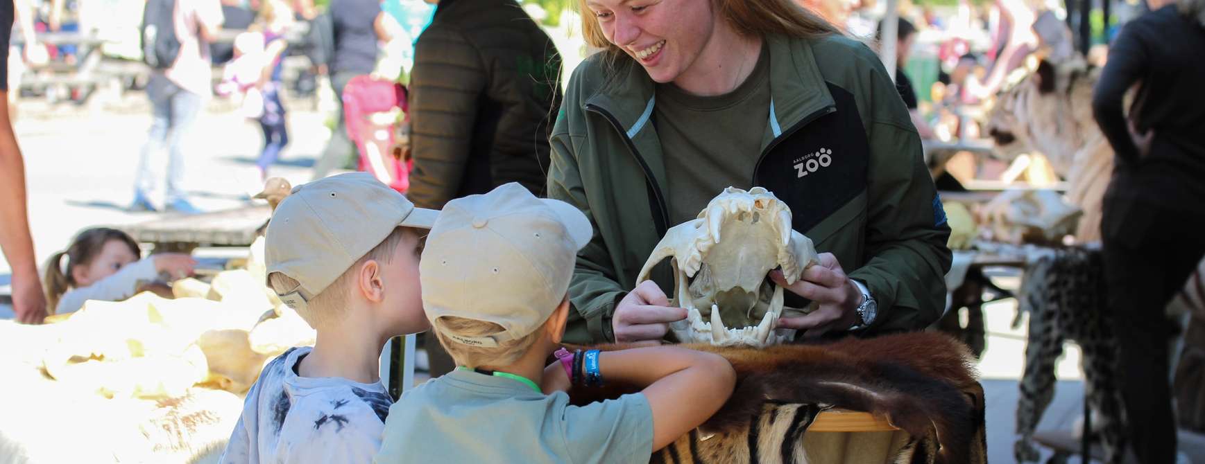 Barn som undervises av en ansatt i dyrehagen. Foto