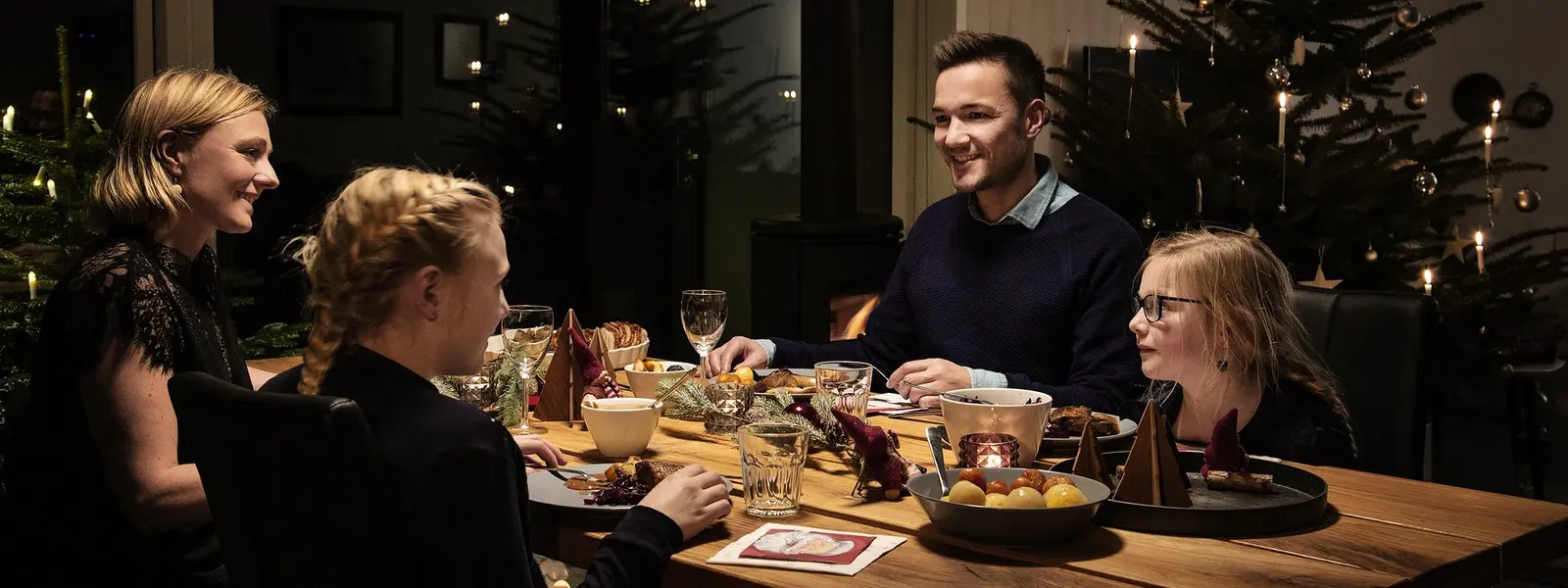 Familie som sitter ved bordet klare til å spise julemat.