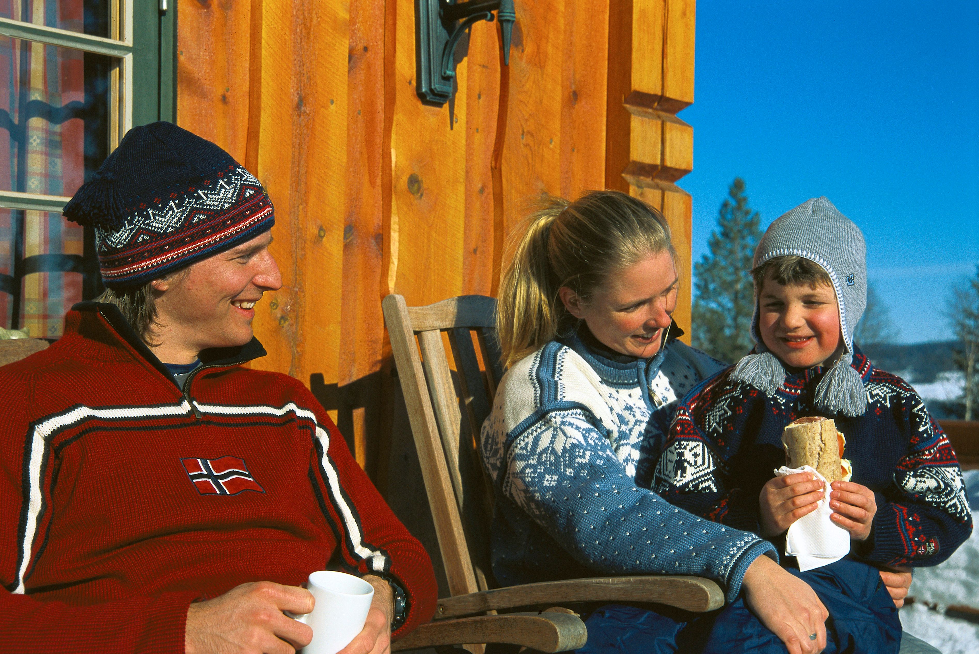 a man and a woman are sitting on a porch with a child .