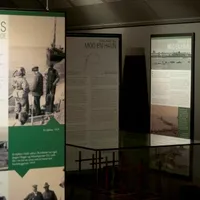 En museumsutstilling som viser informasjonstavler om dykkerarbeid og havnehistorie, inkludert bilder av dykkere og historiske havneanlegg.