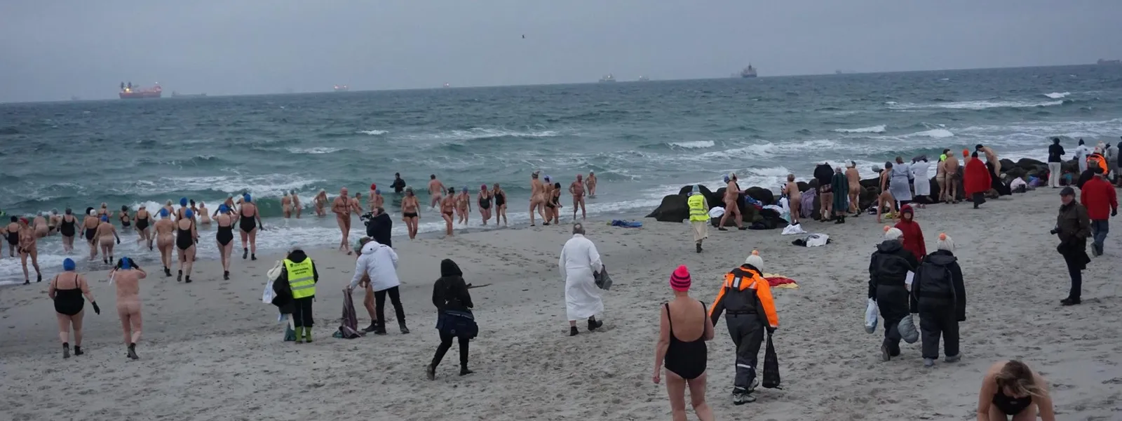 Strand om vinteren med mange badegjester.