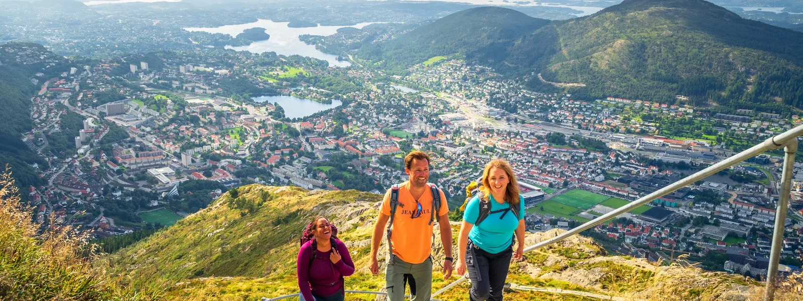 Three people kayaking on calm waters in red kayaks, enjoying an outdoor adventure on a sunny day.