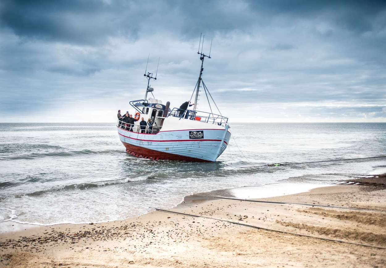 En av båtene blir vinsjet opp på stranden. Foto: Visit Denmark/@FlyingOctober