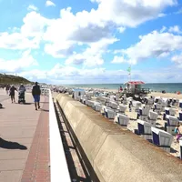 strandpromenade med sand, strandstoler og sjø