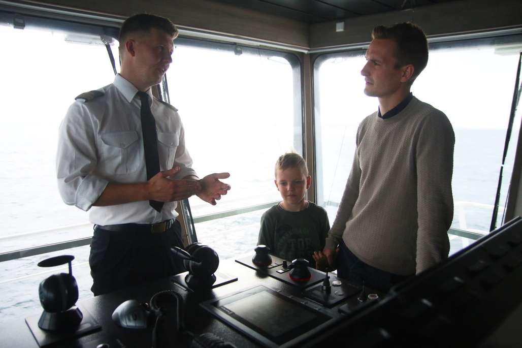 Førstestyrmann, gutt og hans far på brua på et skip.