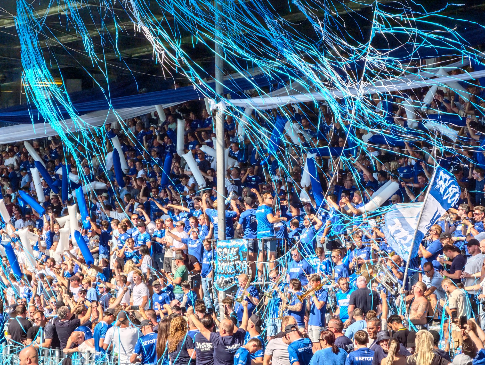 Voller Heimblock des FC Den Bosch mit blau-weißen Luftschlangen und Fahnen beim Spiel gegen Almere City.