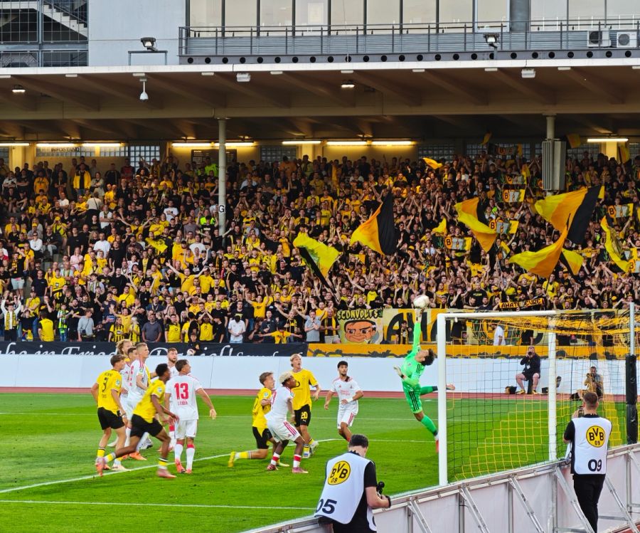 Spielszene zwischen BVB U23 und 1. FC Köln U21 vor der dicht besetzten Dortmunder Kurve in der Roten Erde.