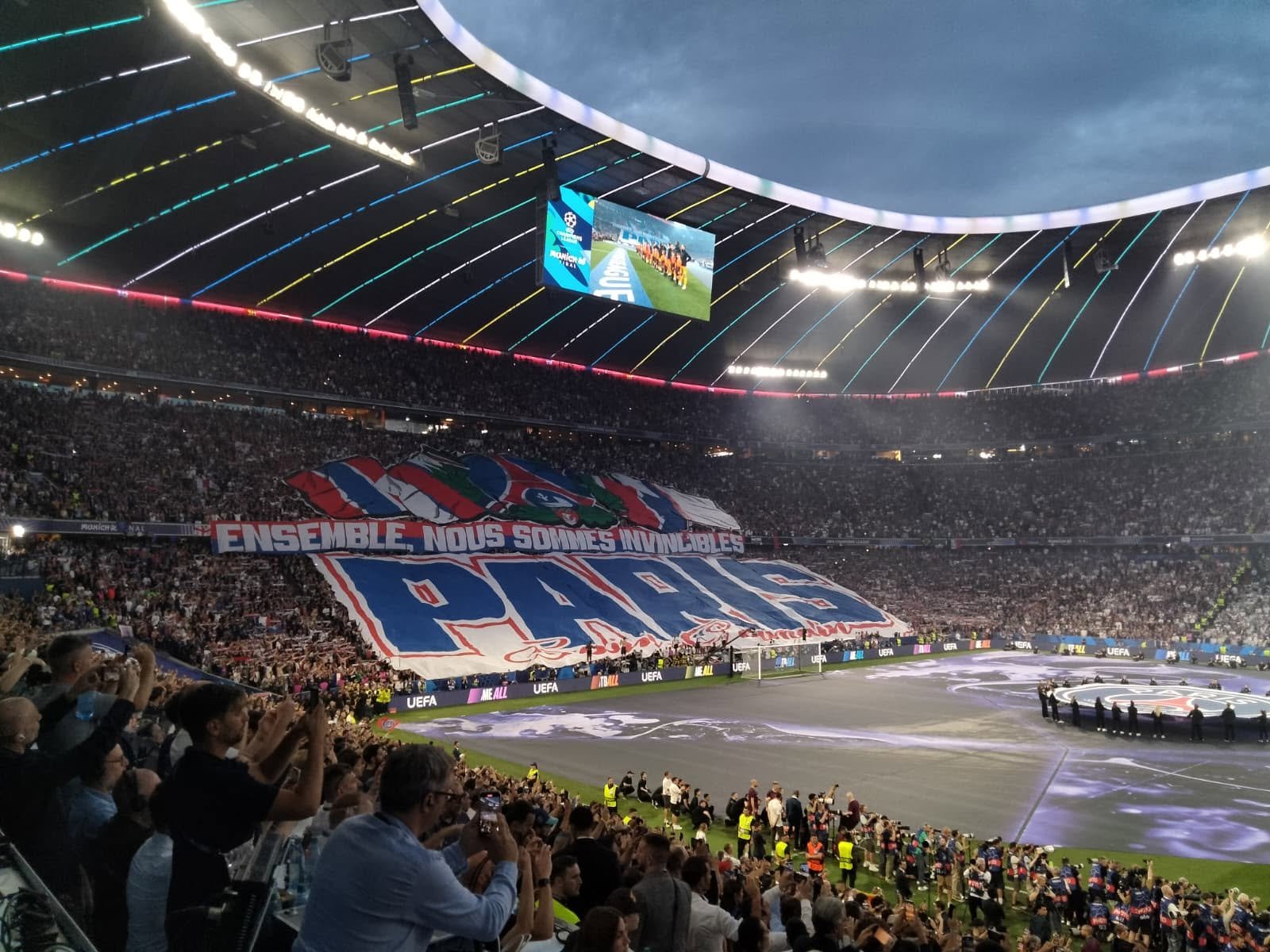 Große Choreografie der PSG-Fans beim Champions-League-Finale 2025 gegen Inter Mailand in der Allianz Arena München. Eine riesige Blockfahne mit PSG-Schriftzug und dem Spruch „Ensemble, nous sommes invincibles“ bedeckt die Pariser Fankurve.