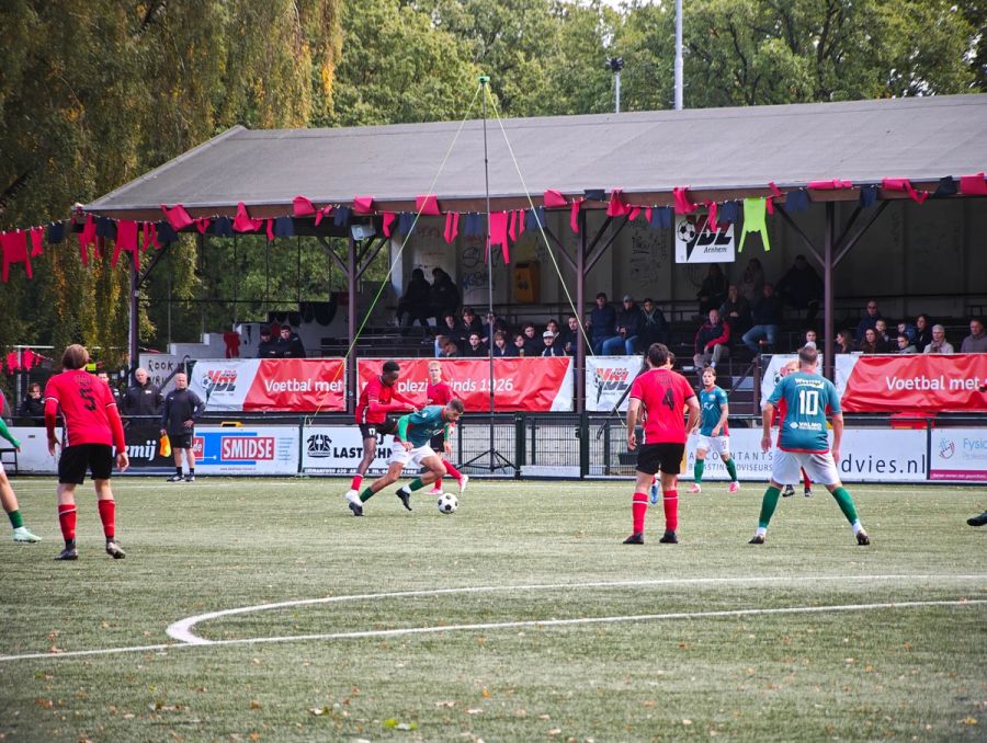 Historische Holztribüne von VDZ Arnhem im Sportpark ’t Cranevelt während eines Fußballspiels gegen VV Germania. Die überdachte Tribüne mit Holzbänken und rot-schwarzer Dekoration zählt zu den ältesten Tribünen der Niederlande.