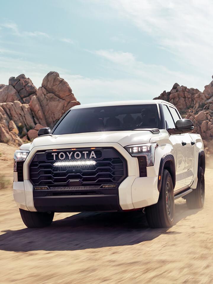 white Toyota Tundra parked in front of giant rocks