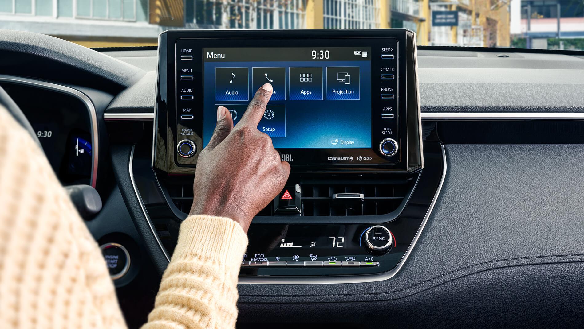 Woman using touch screen display in Toyota Corolla Cross