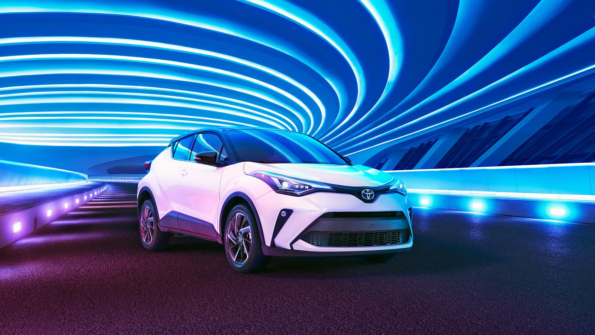 white Toyota C-HR in a blue lighted tunnel at night