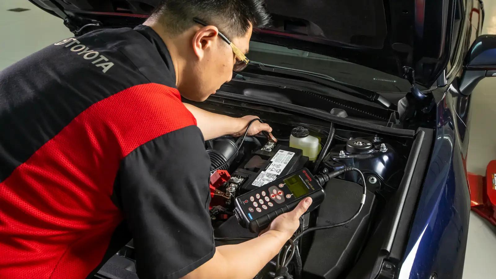 Toyota certified male tech testing a battery