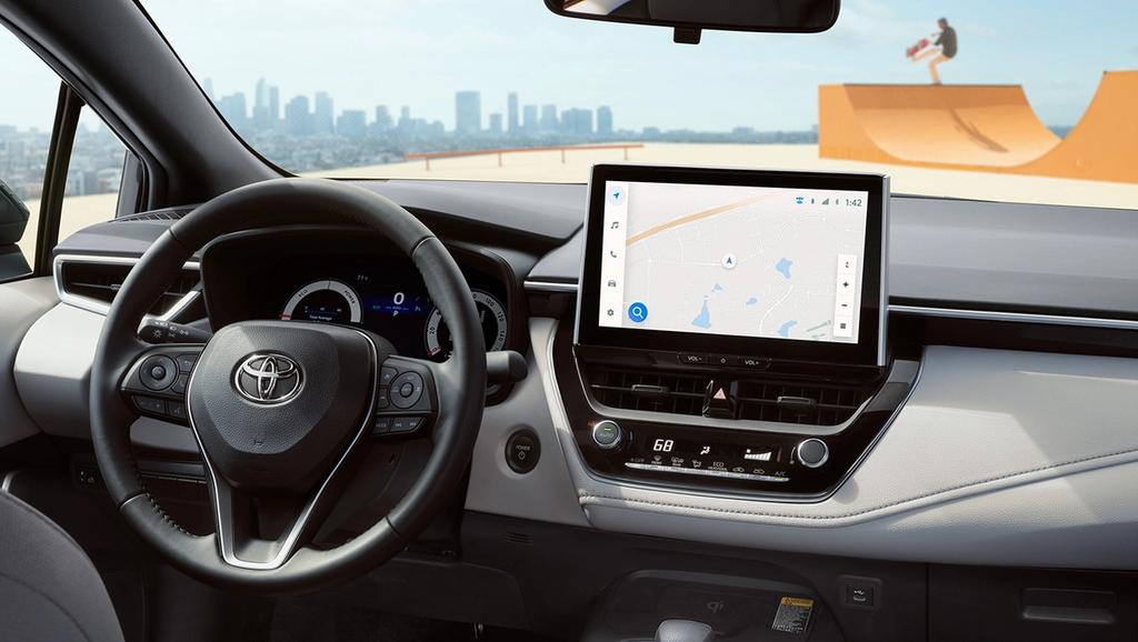 Interior view of a Toyota corolla showing the steering wheel, digital dashboard, and a touchscreen navigation system.
