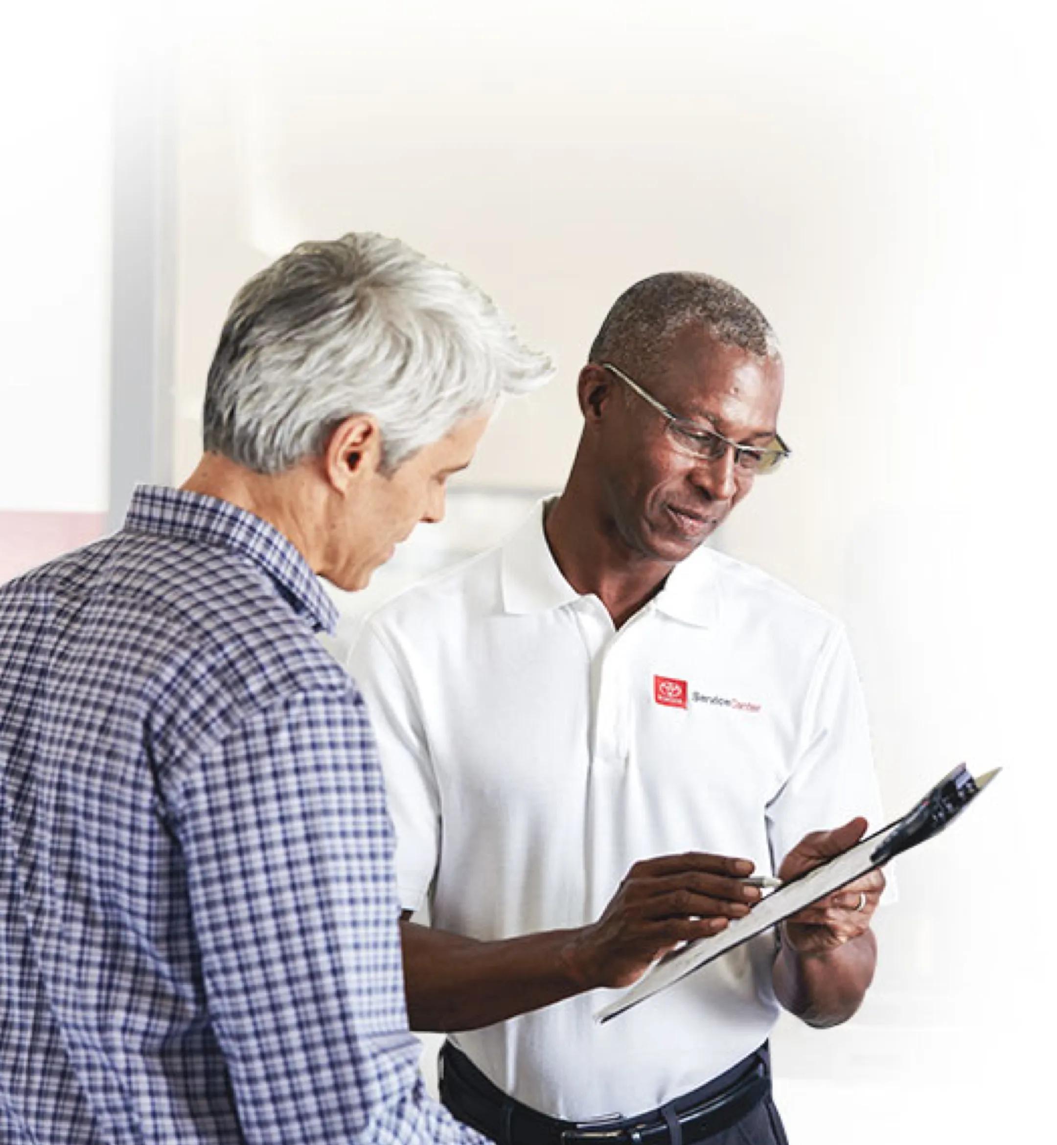 Toyota certified technician going over paperwork with a customer