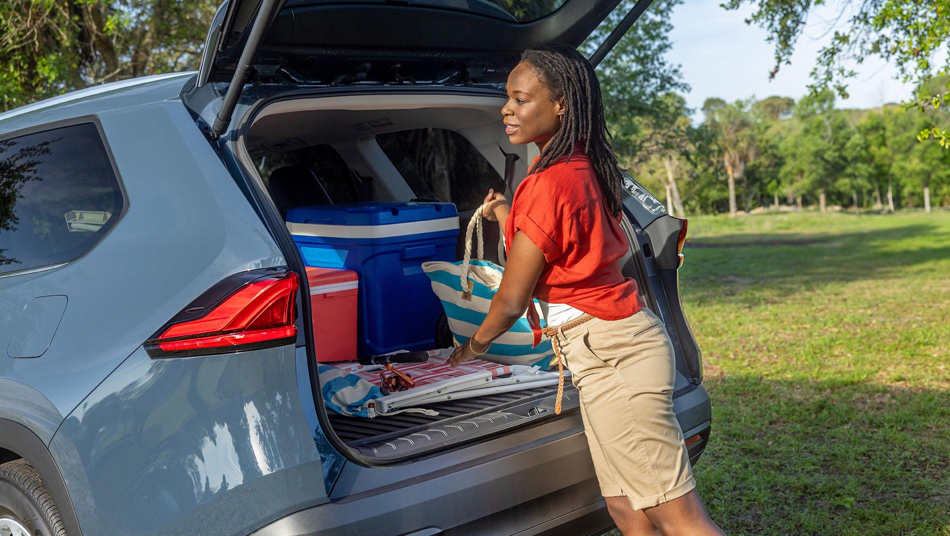 Toyota Hybrid SUV with a woman loading picnic items into the back - part of Toyota's Beyond Zero initiative