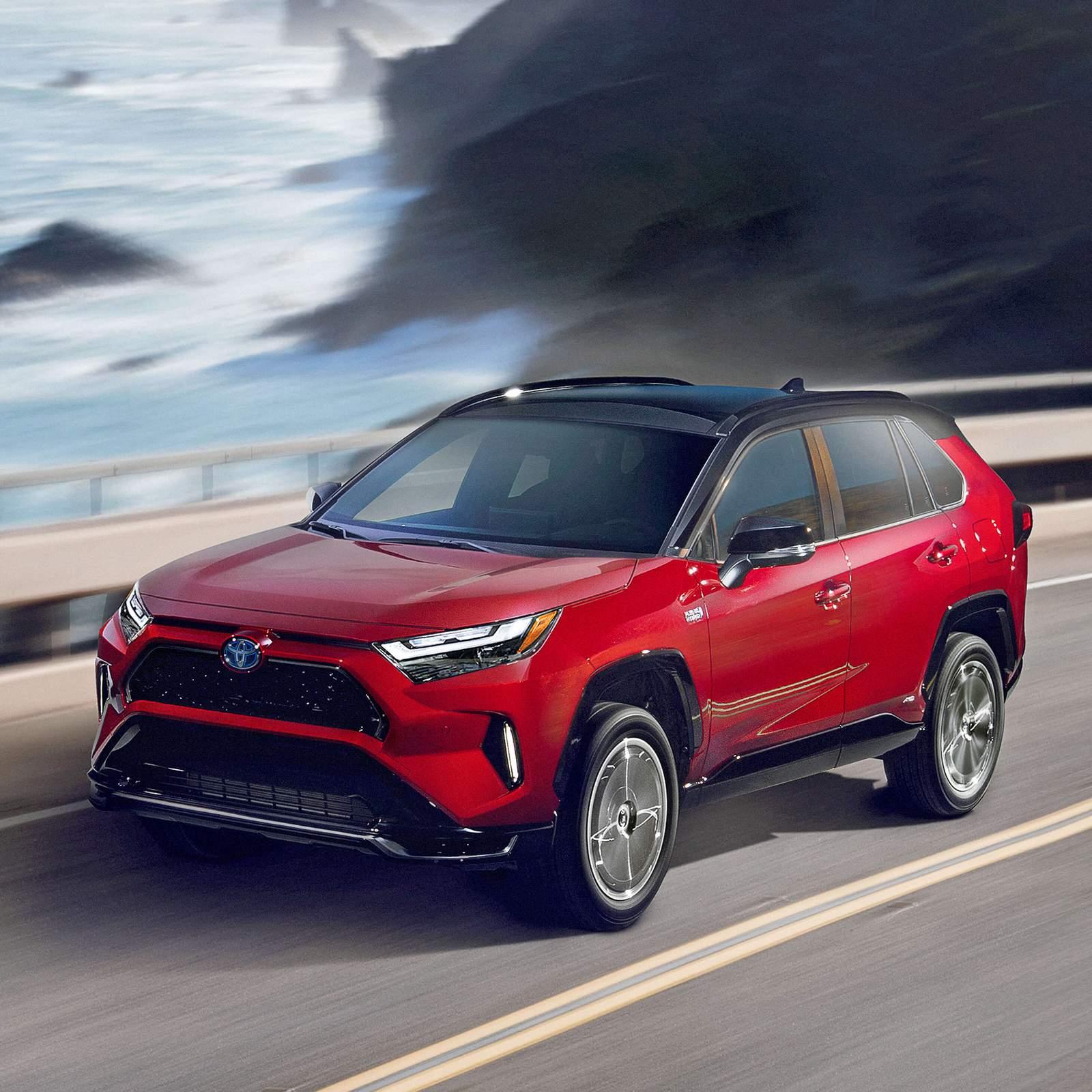 red Toyota RAV4 Prime plus in hybrid driving on a bridge over water