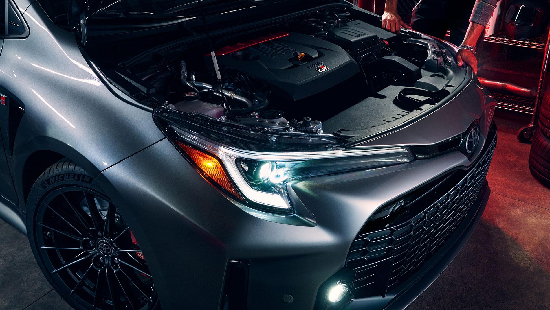 2024 Toyota GR Corolla with the hood open and the headlights on