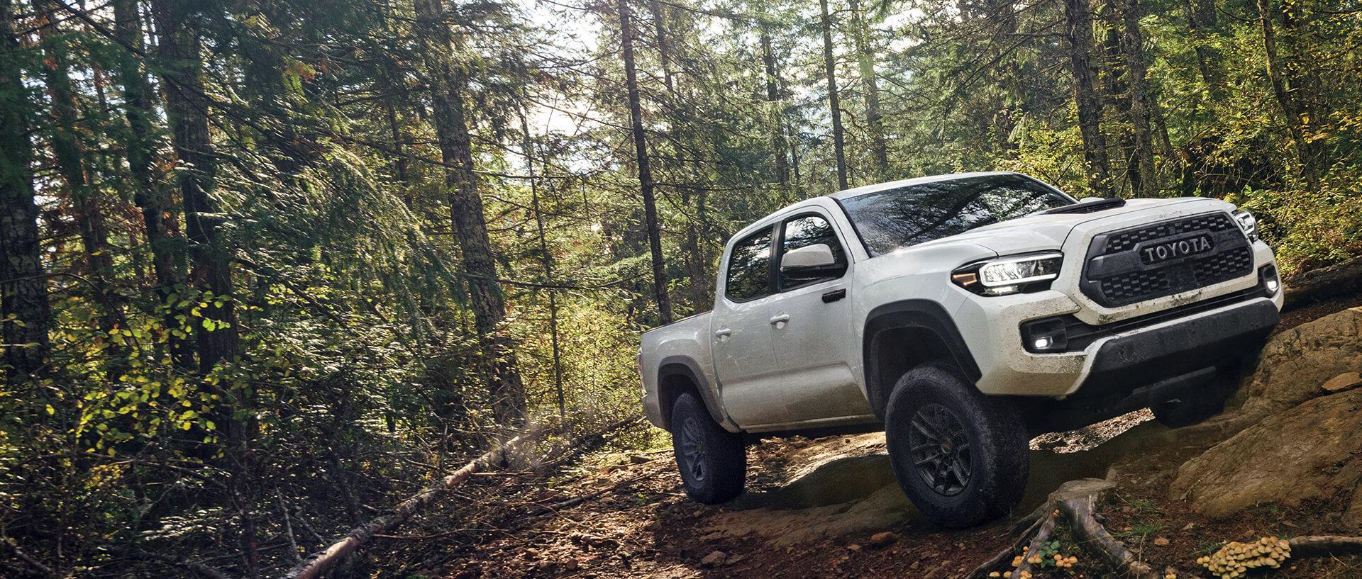 Toyota truck climbing mountain with lots of trees around