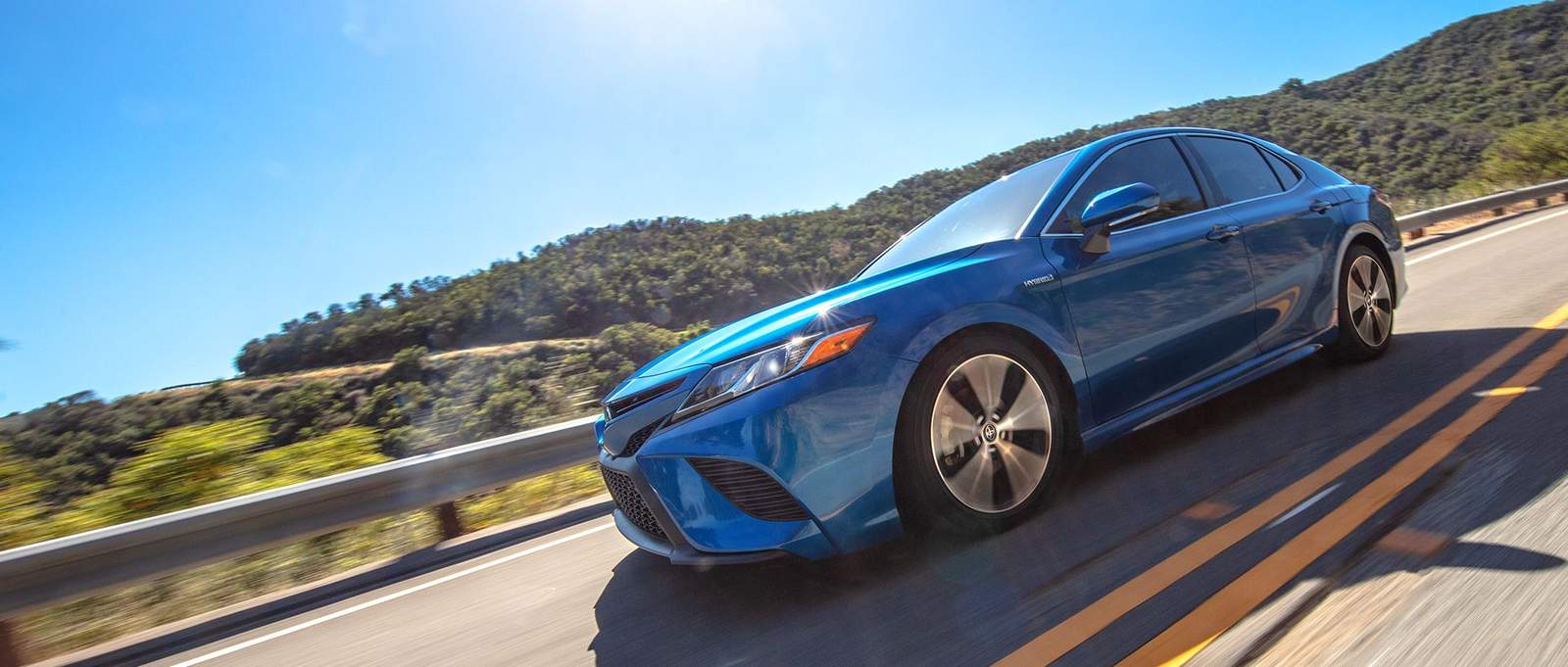 2023 Toyota hybrid Sedan driving on a steep mountain road