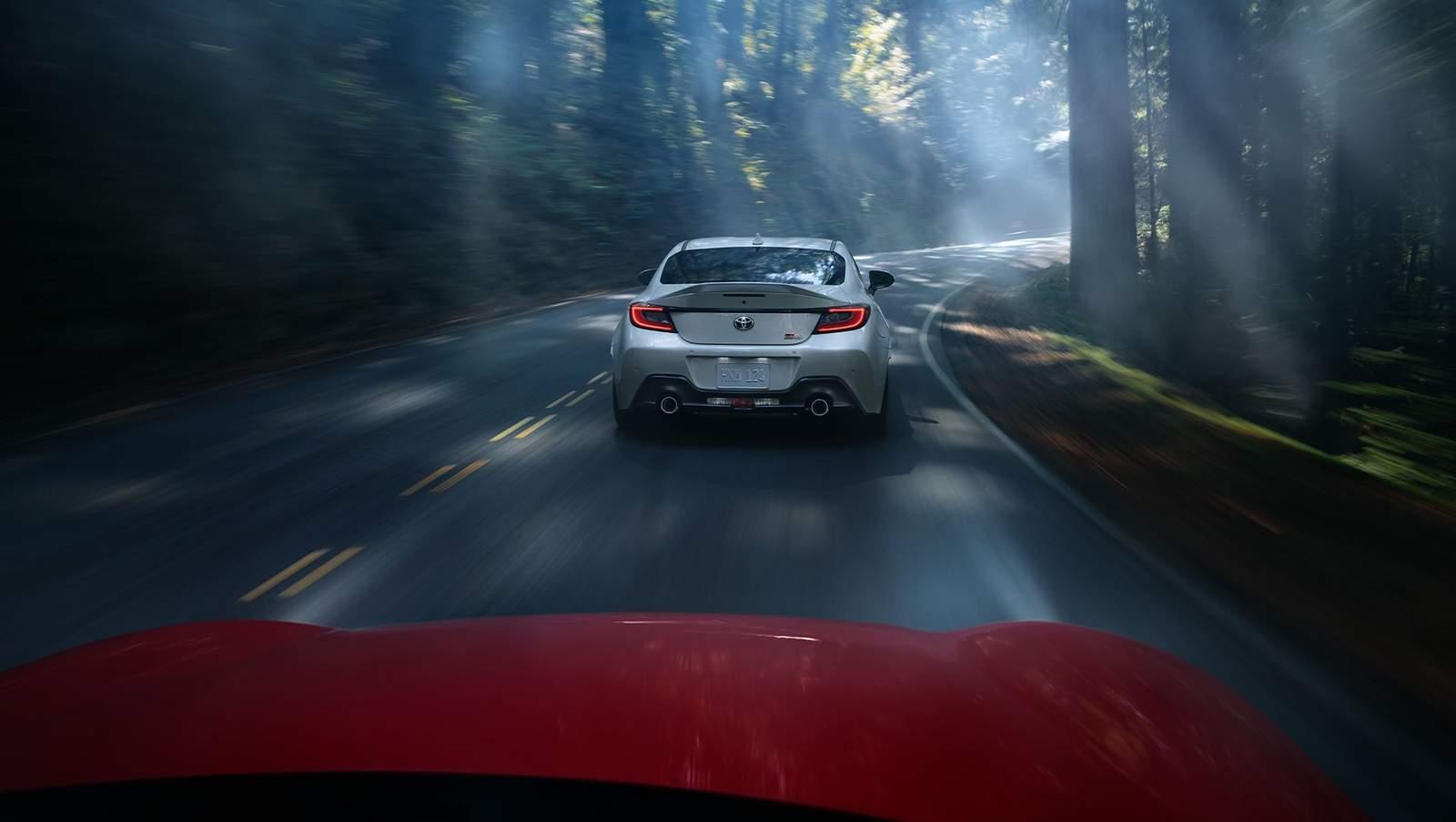 Toyota GR Supra driving down a windy deep mountain road