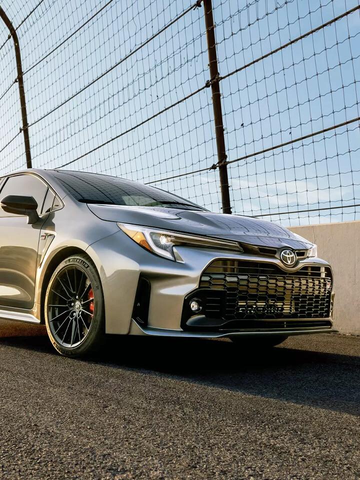2023 Toyota GR Corolla on race track along fence