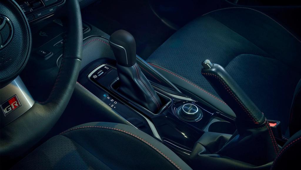 An image of the gear shifts and emergency brake for the 2025 toyota gr corolla. It is colored black with red outlining.