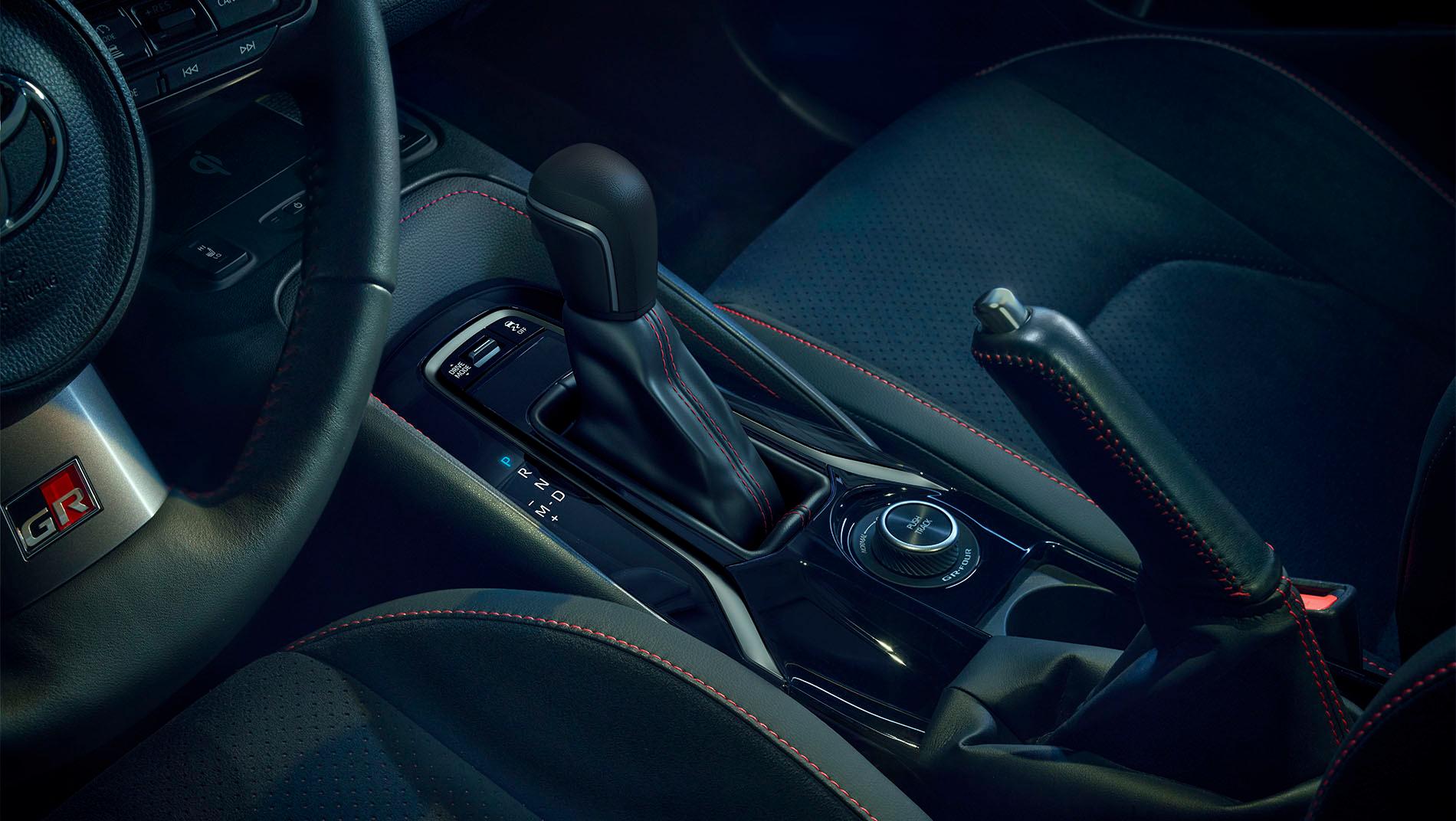 An image of the gear shifts and emergency brake for the 2025 toyota gr corolla. It is colored black with red outlining.