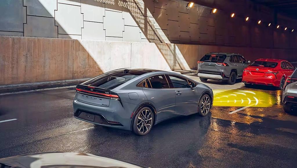 2023 Toyota Prius Prime driving down a city road through a tunnel with distance safety sensors