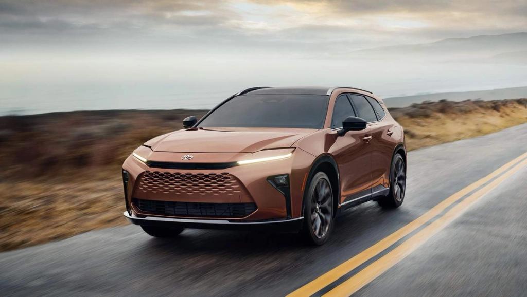 brown 2025 Toyota Crown Signia driving down a mountain road
