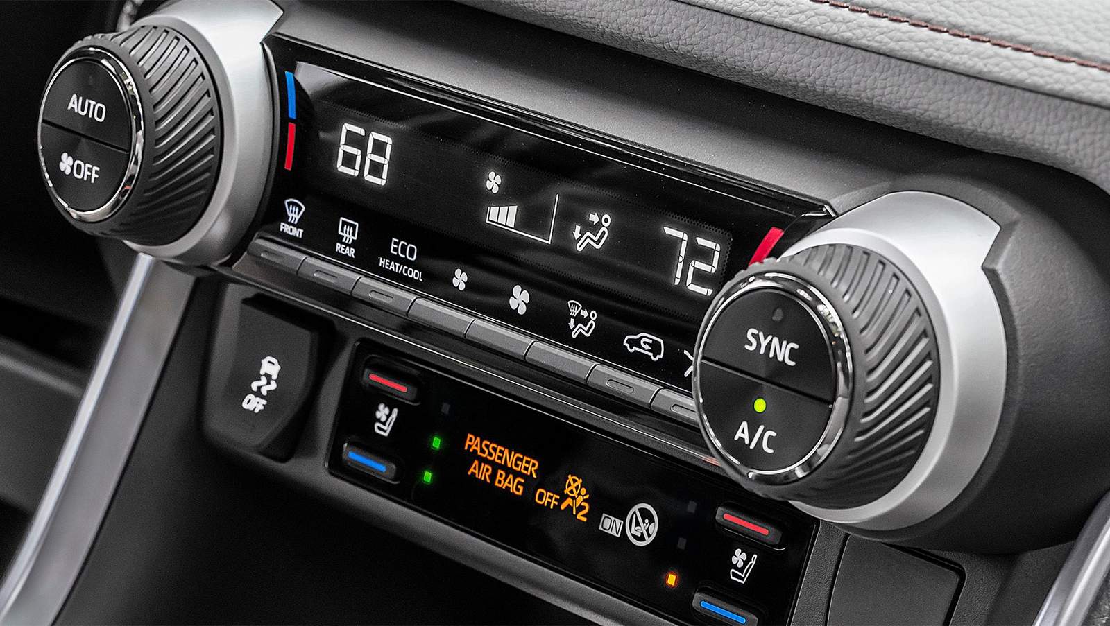 Close-up of a car's digital climate control system. The display shows a dual temperature setting of 68°F and 72°F.