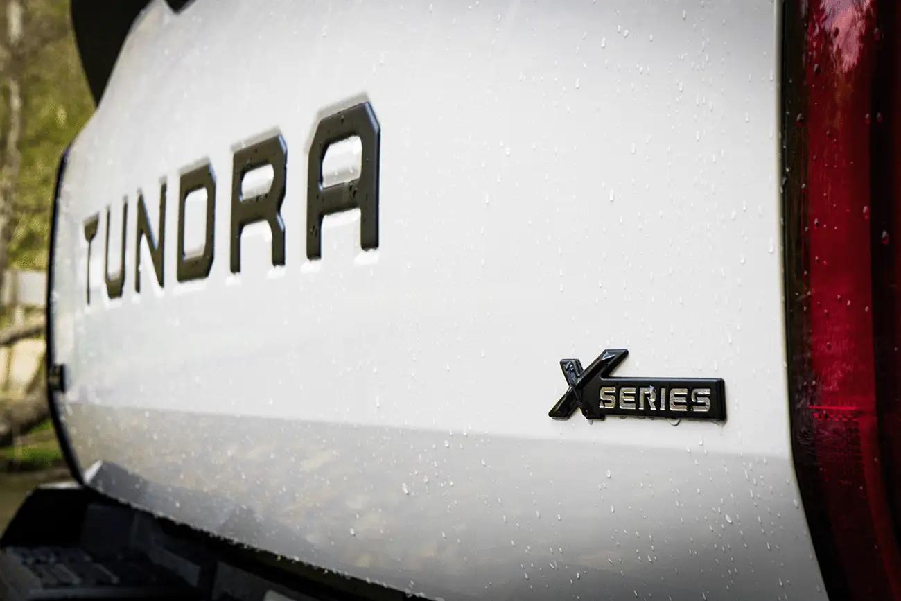 close up of the back tail gate of a 2024 white Toyota Tundra XP XSeries upgraded accessories package showing black emblems