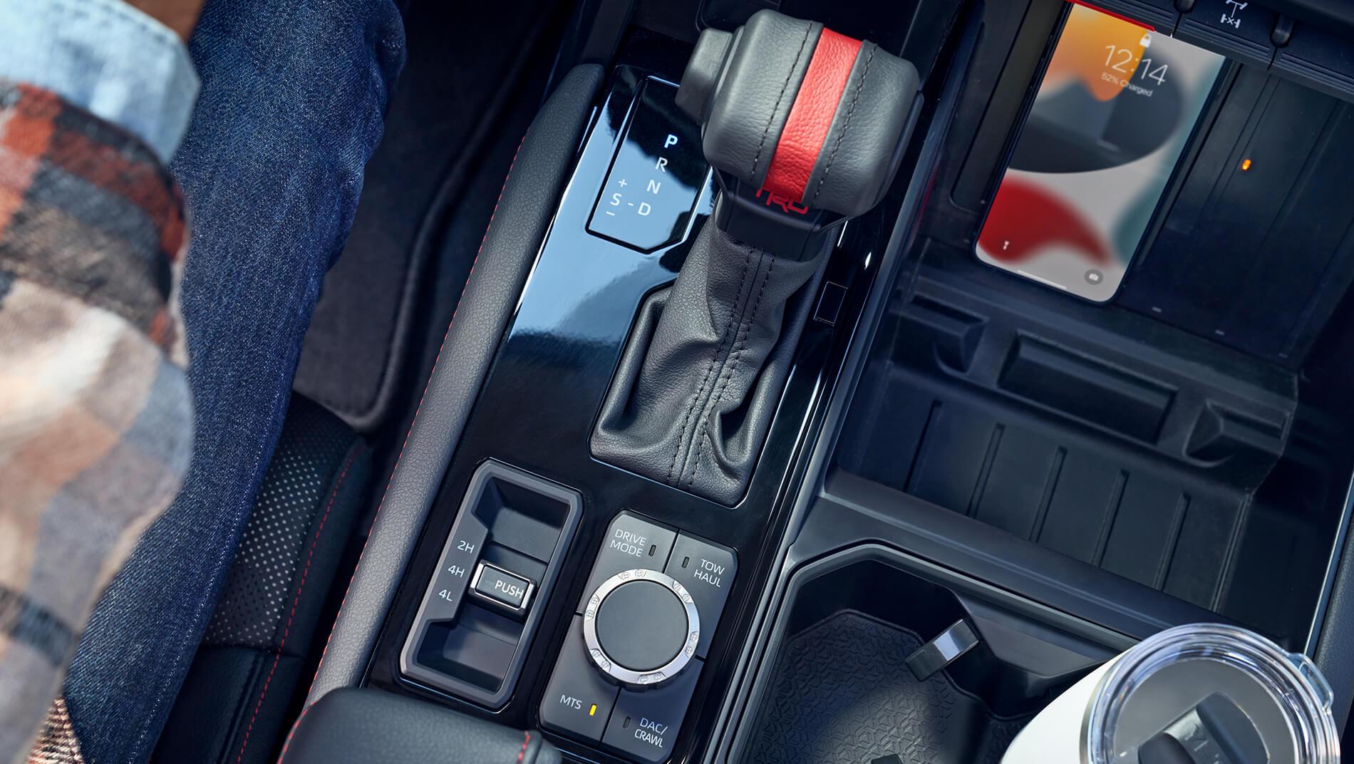 inside of a Toyota Tundra showing wireless phone charger, gear shifter, and tow mode