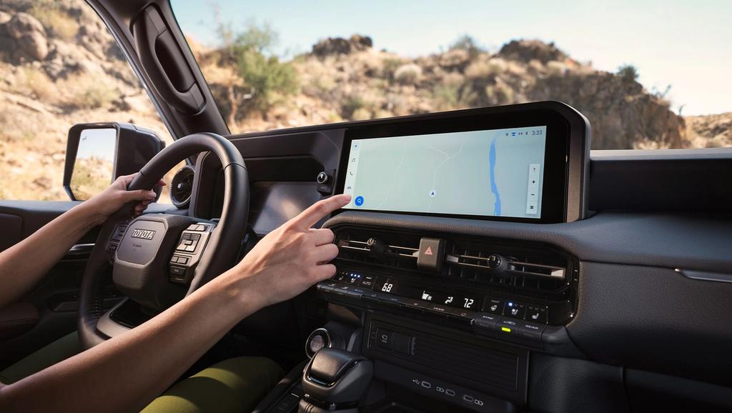 person driving a 2025 Toyota Land Cruiser and using the map on the multimedia navigation touchscreen
