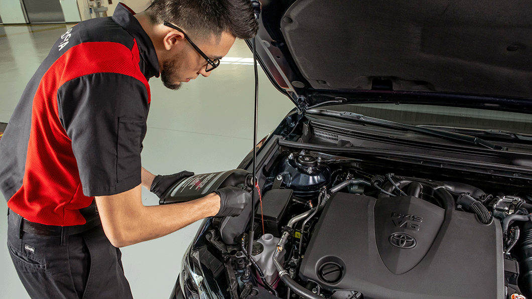 Toyota Certified Technician working on the engine of a Toyota