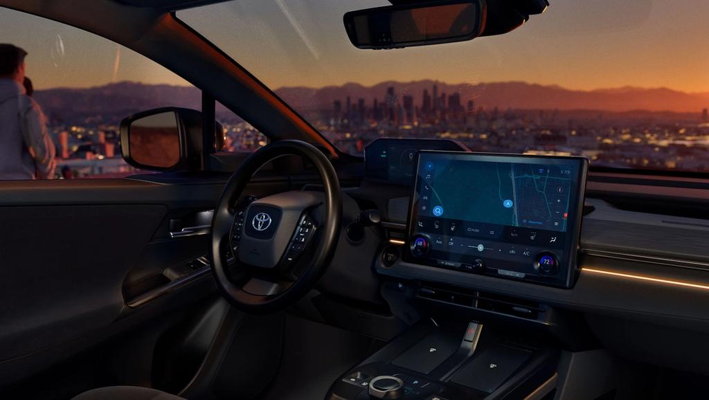 A modern car interior at sunset with a digital dashboard and navigation screen, showing a city skyline in the background through the windshield and a person standing outside.