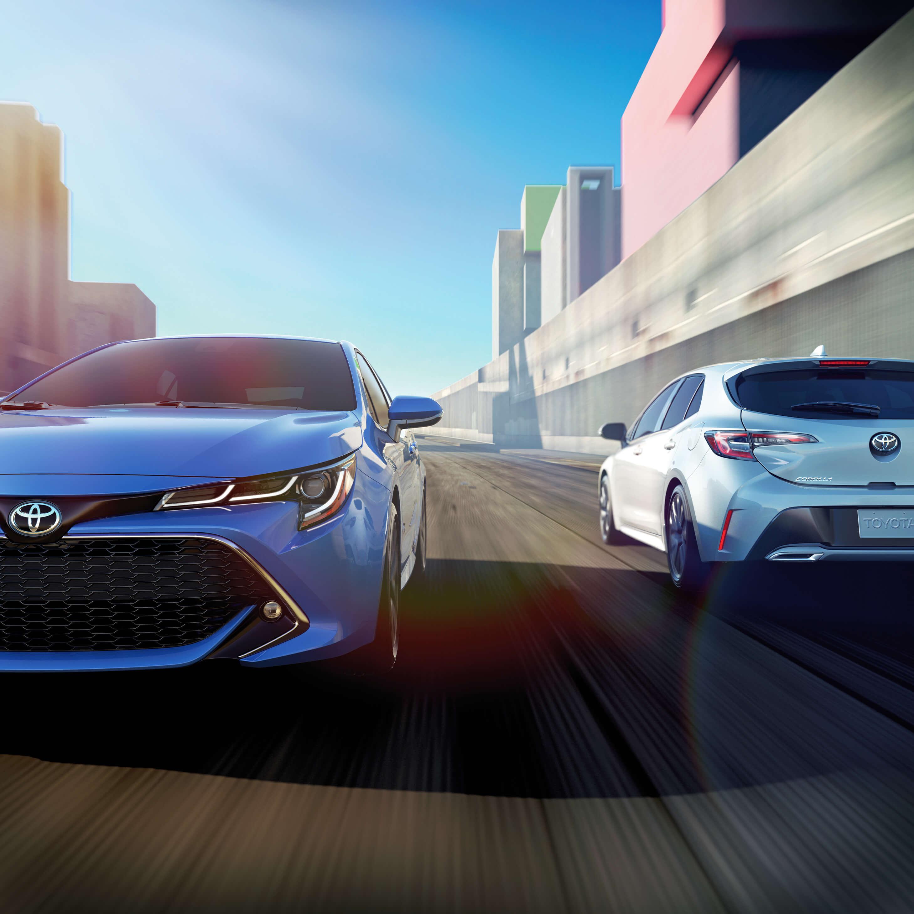 2 Toyota Corolla Hatchback's passing each other on the street