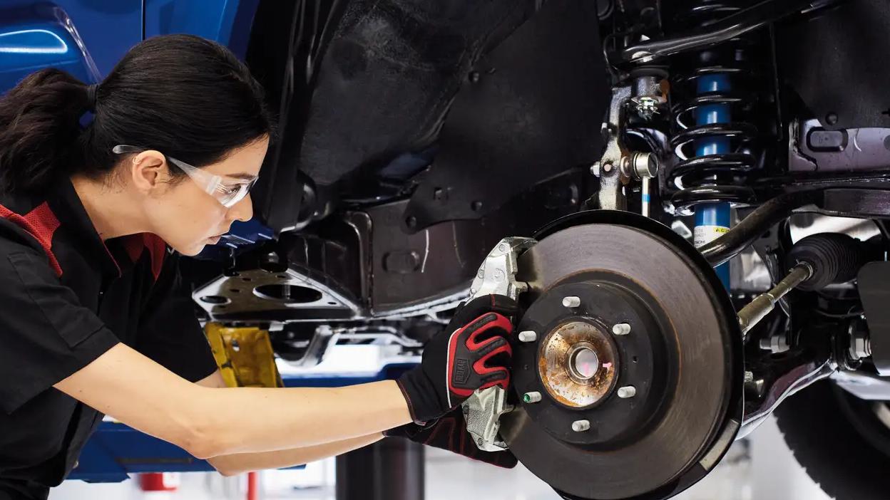 Toyota certified technician female changing brakes