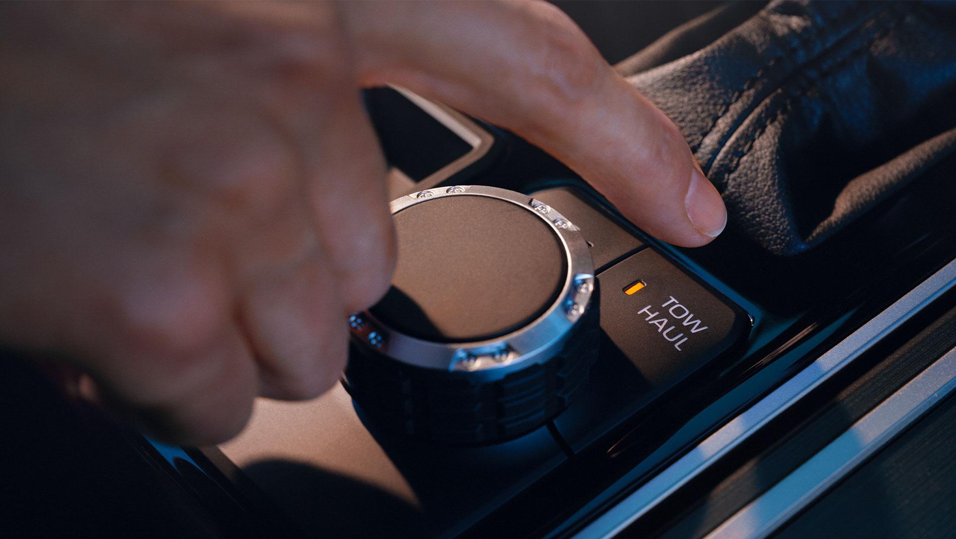 An image of someone pressing the tow/haul button for the 2025 Toyota Sequoia i-FORCE MAX Hybrid.