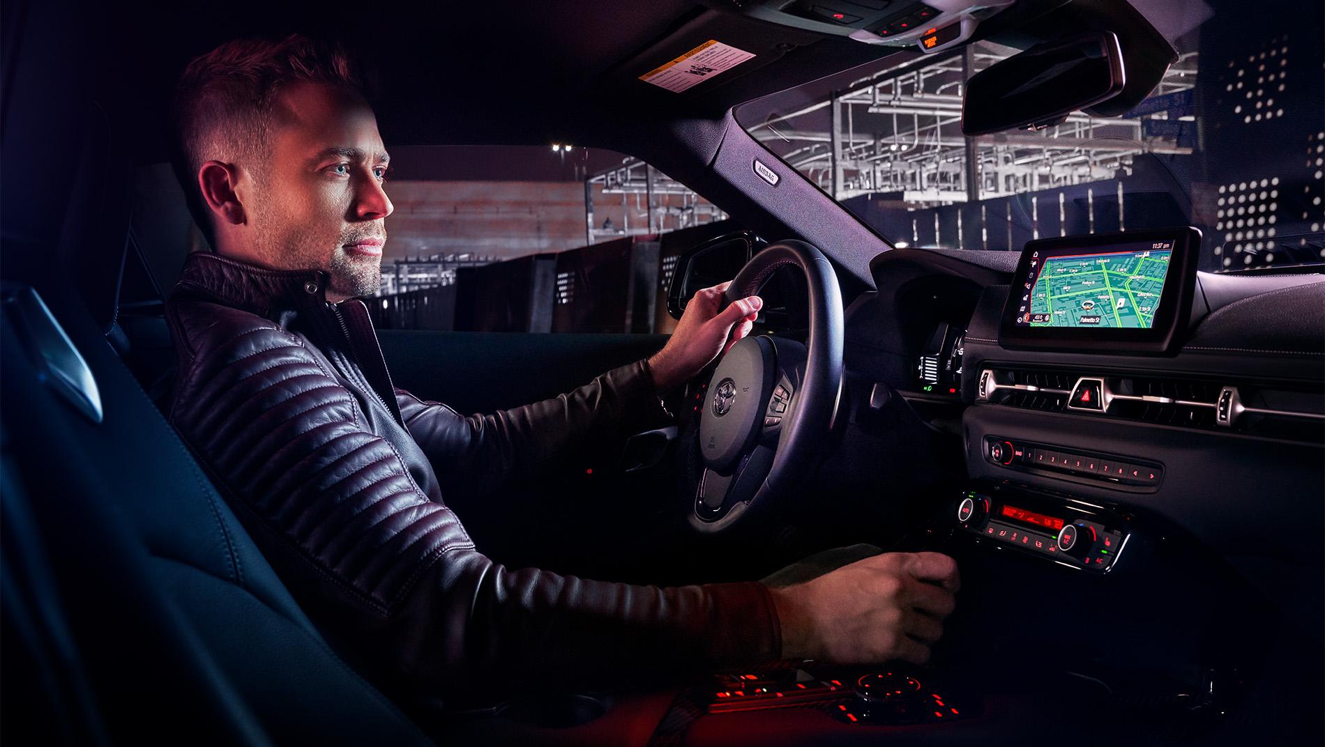 white man driving a Toyota GR Supra showing interior LED Smart Lighting
