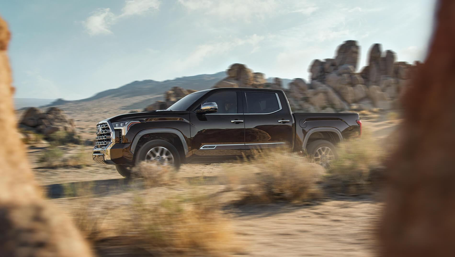 Black Toyota Tundra driving through rocky mountains