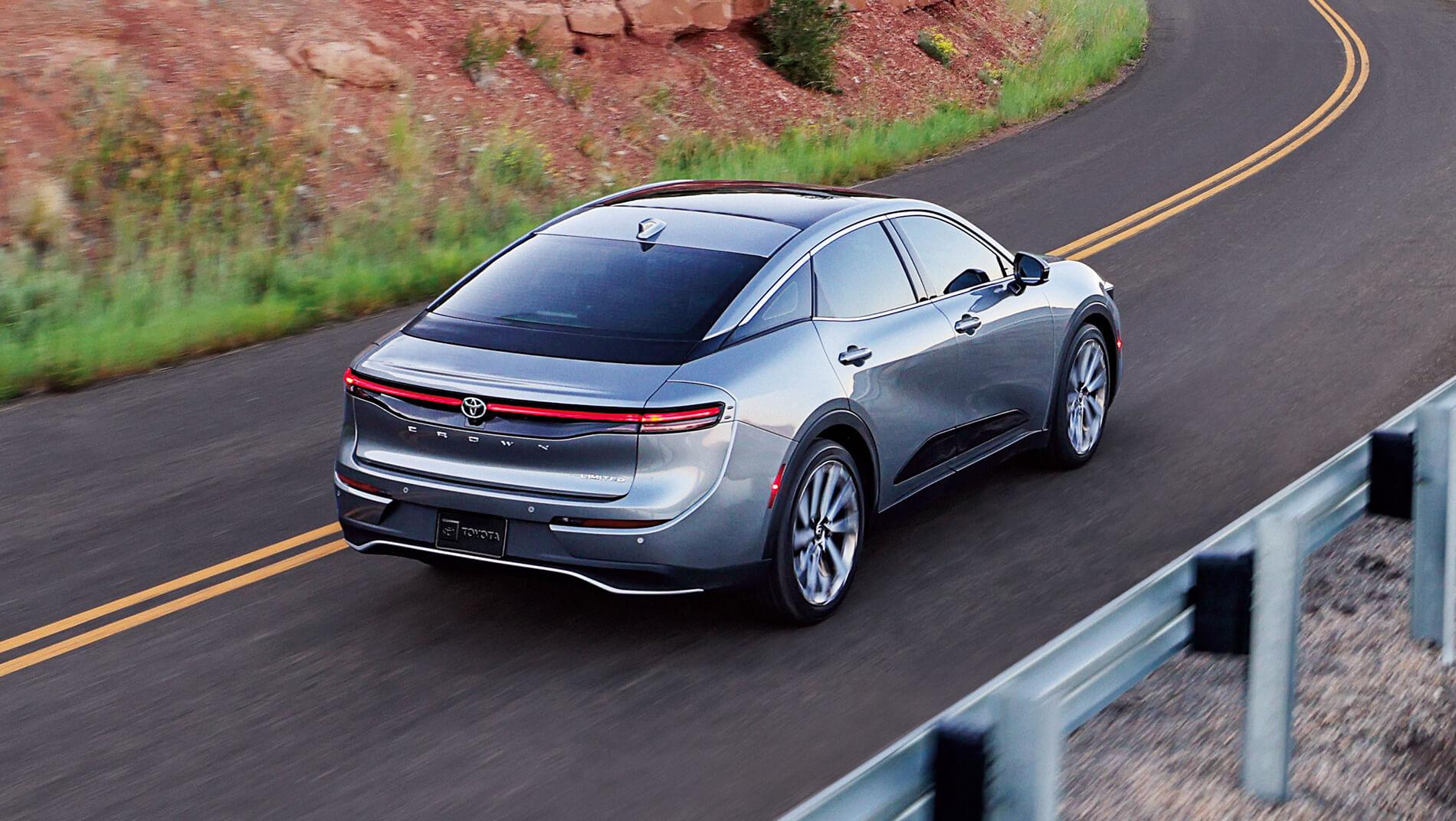 exterior image of a Toyota 2023 Crown driving down a curve on a mountain road