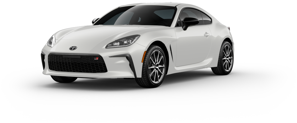 An exterior view of a white Toyota GR86 sports car viewed from the rear and side, showing dual exhaust pipes, a rear spoiler, sleek taillights, and sporty alloy wheels