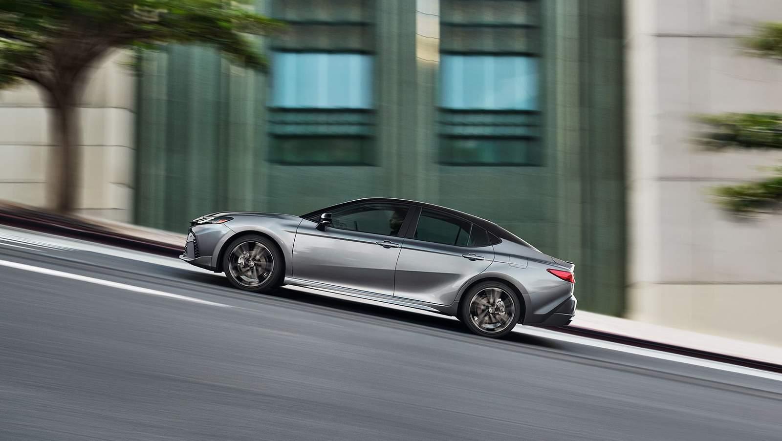 Silver and black 2 tone Toyota Camry driving up a steep city hill