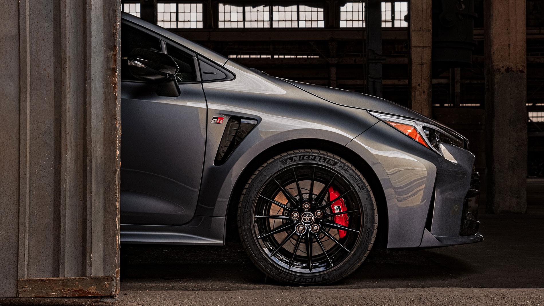 the front side of a 2024 Toyota GR Corolla coming out of a dark warehouse