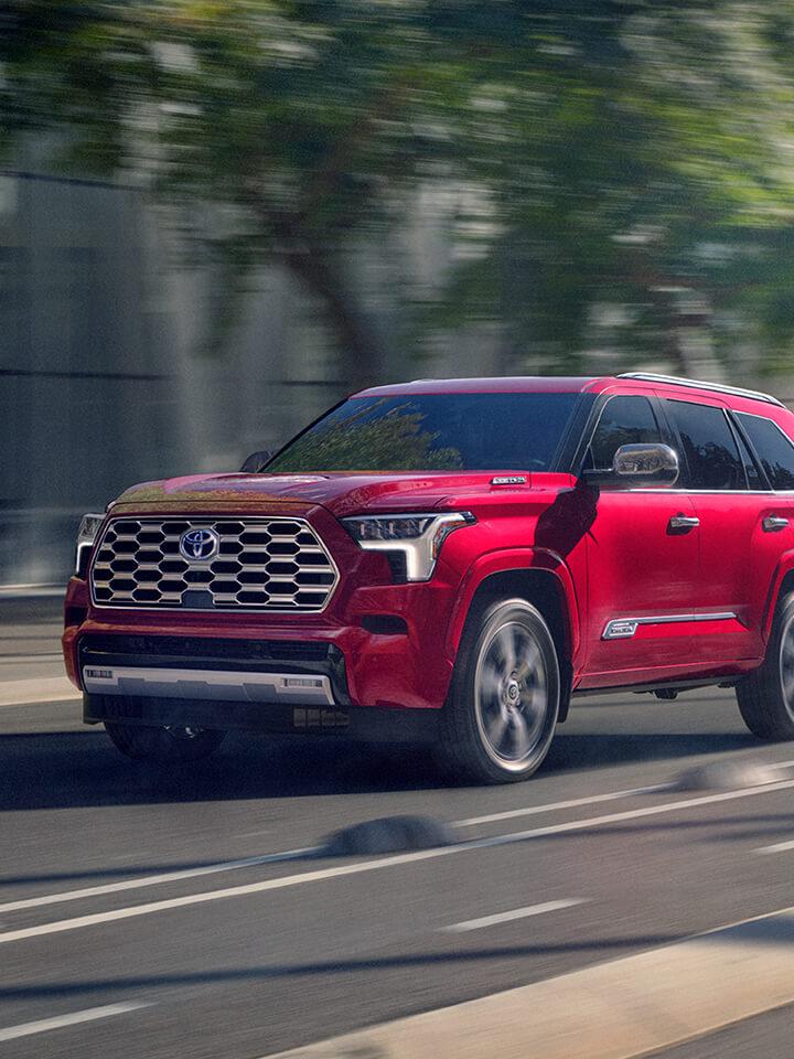 2024 Toyota Sequoia in red driving down a city street