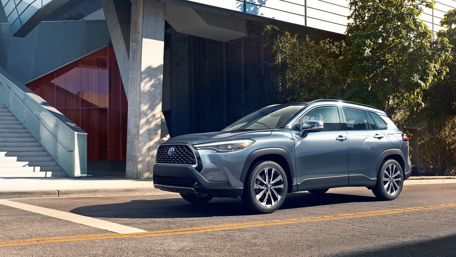 blue Toyota Corolla Cross driving down city