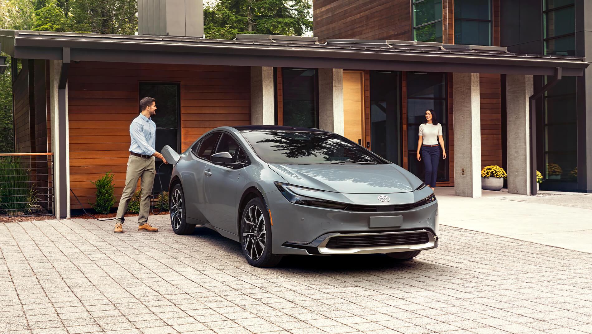 2023 Toyota Prius Prime in grey charging in front of a modern home
